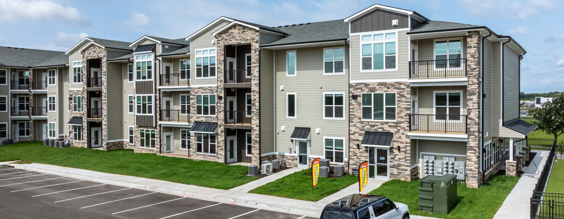 an apartment building with a car in a parking lot